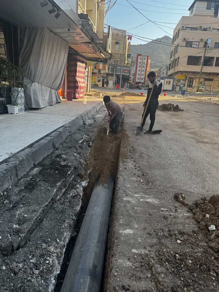 Workers installing pipe in a trench