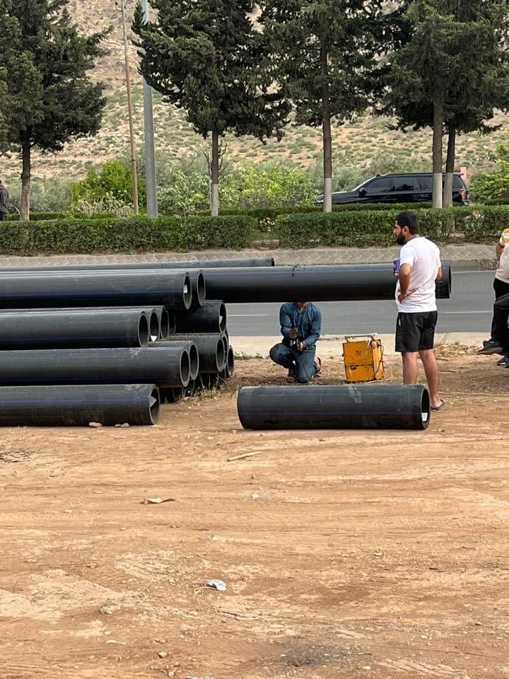 Workers installing pipe in a trench
