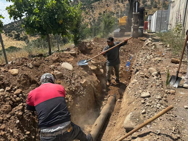 Workers installing pipe in a trench