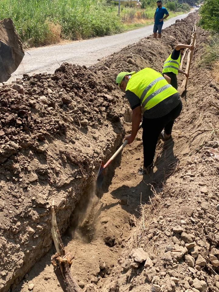 Workers installing pipe in a trench