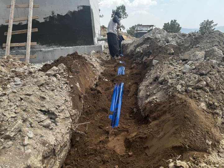 Workers installing pipe in a trench