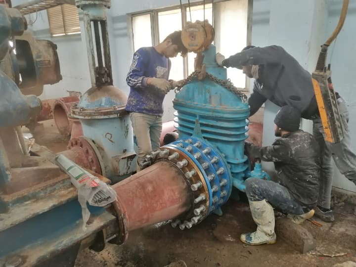 Workers installing pipe in a trench