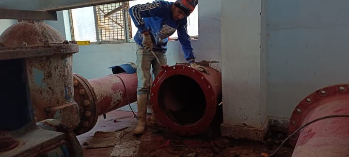 Workers installing pipe in a trench