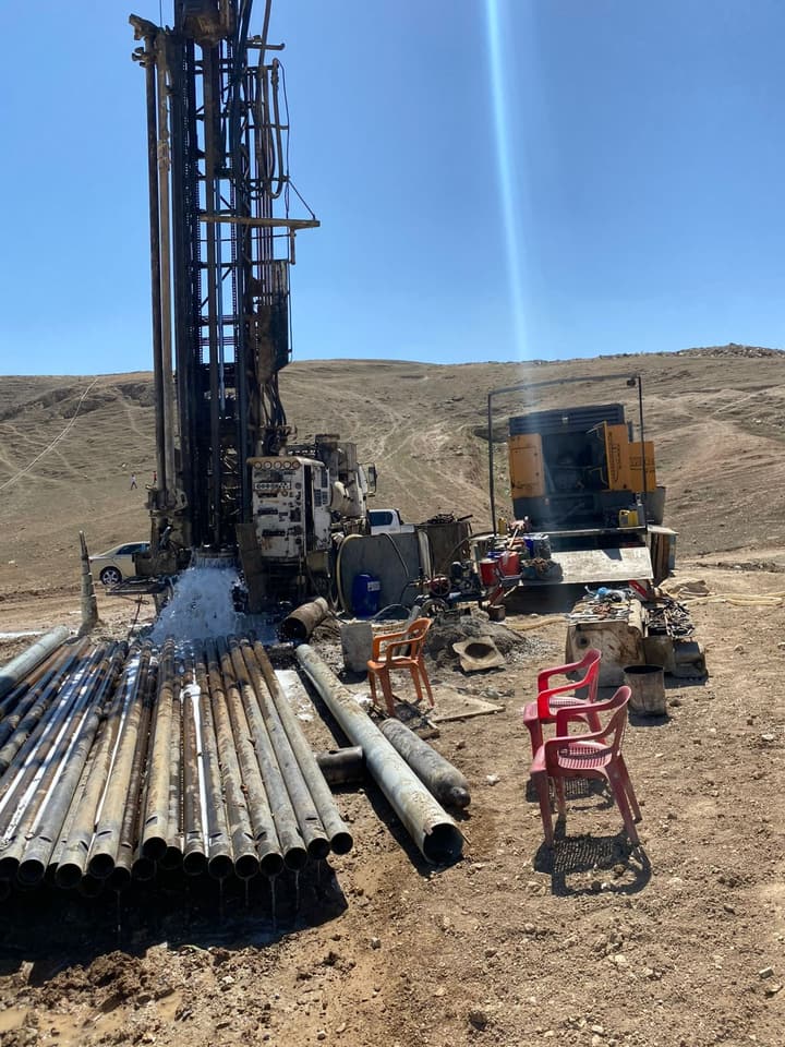 Workers installing pipe in a trench